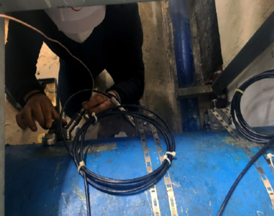 Technician installing Panametrics AquaTrans AT600 clamp-on transducers on a raw water pipeline